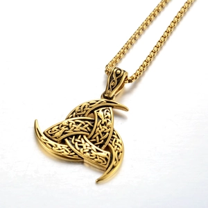 Primer plano detallado del colgante vikingo Triskelion dorado con cadena sobre fondo blanco