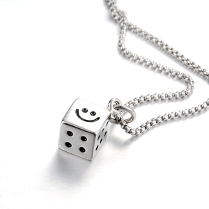 Vue macro d'un pendentif dé argenté avec motif sourire sur une chaîne vénitienne hip-hop