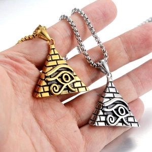 Macro detail of Eye of Horus pyramid pendant in gold and silver stainless steel finish