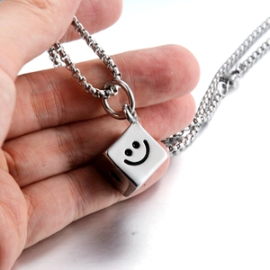 Gros plan du pendentif dé souriant de style hip-hop sur une chaîne à maillons