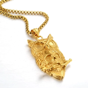 Detail der goldenen Eulen-Totenkopf-Halskette mit Federstrukturen und Box-Kette