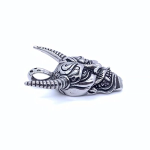 Detailed macro view of retro stainless steel Hannya mask pendant with antique finish