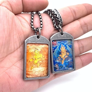Detalle de colgantes Thangka tibetanos vintage con motivos religiosos y cadenas de metal