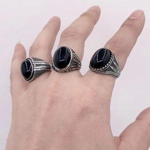 Close-up of vintage titanium steel rings for men featuring large oval black gemstones