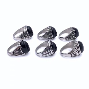 Detail view of six vintage men's stainless steel rings featuring oval black gemstones