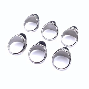 Macro detail of men vintage titanium steel rings with oval black gemstone and carved textures