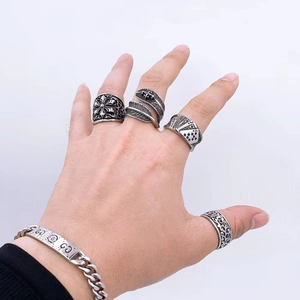Nahaufnahme von Vintage-Stahlringen und Armbandset mit Kreuz- und Federmotiven