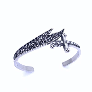 Macro detail of gothic sword cuff bracelet with black diamonds in vintage steel finish