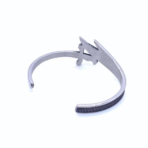 Close-up of vintage punk style men's titanium steel cuff with black textured details