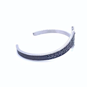 Detail of vintage silver titanium steel open bracelet with black crystal diamond texture