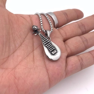 Gros plan du pendentif pipa en acier titane rétro avec finition vintage et chaîne box