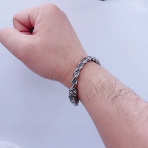 Détail d'un bracelet jonc torsadé pour homme en acier inoxydable avec tête de loup