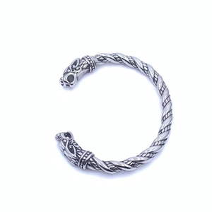 Gros plan détaillé de la gravure tête de loup viking sur un bracelet en acier tressé