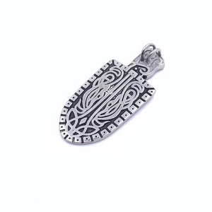 Macro view of vintage shield pendant featuring Nordic Viking knotwork and distressed silver finish
