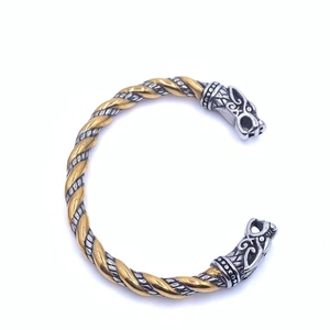 Détail macro du bracelet tête de loup viking avec fils torsadés argent et or