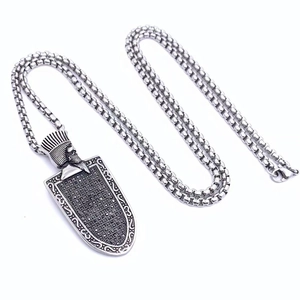 Macro shot of vintage shield warrior pendant with black zircon and oxidized steel chain