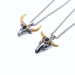 Détail macro de pendentifs tête de taureau punk rétro avec cornes dorées et pierres noires