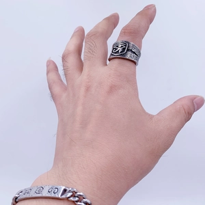 Macro view of vintage titanium steel ring featuring Eye of Horus relief and textured edges