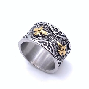 Macro de la bague aigle avec pavage de cristaux noirs et détails de relief d'aigle doré