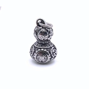 Détail macro du pendentif gourde en argent vintage avec caractères Fu et Shou et nuages