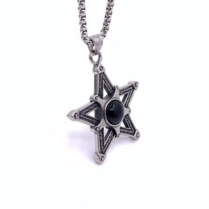 Détail macro d'un pendentif hexagramme vintage avec onyx noir et chaîne à billes en acier