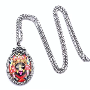 Detailed macro view of the colorful Thangka pendant and the textured silver wheat chain link
