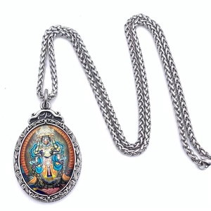 Macro view of oval Thangka pendant with colorful Buddha and vintage metal relief details