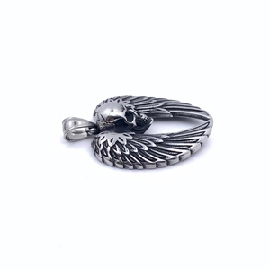 Macro detail of gothic skull pendant with realistic wings in vintage titanium steel