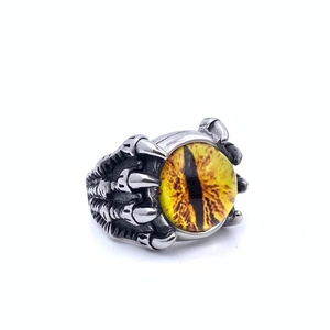 Detail of vintage punk dragon claw ring with a striking yellow evil eye gemstone center