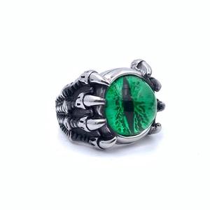 Macro shot of punk style dragon claw ring holding a green evil eye gemstone