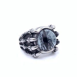 Detail of vintage punk dragon claw ring with blue demon eye stone and silver finish