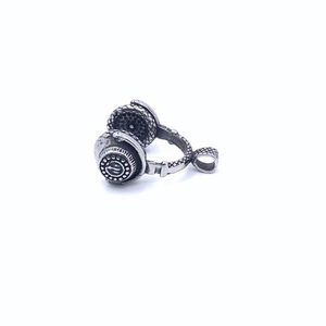 Détail macro du pendentif casque avec textures industrielles et finition argent poli