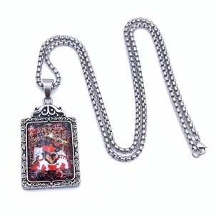 Vue détaillée du pendentif Thangka rectangulaire avec motif coloré de divinité bouddhiste