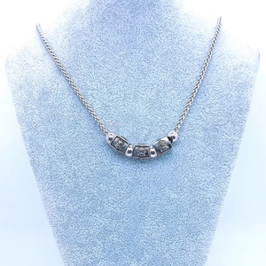 Detailed view of titanium steel necklace with three square Buddha head engraved beads