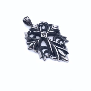 Macro shot of Gothic silver cross pendant with intricate vine engravings and metal textures