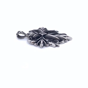 Macro shot of vintage titanium steel cross pendant with detailed gothic floral patterns