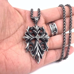 Detail of vintage gothic cross pendant and floral carved ring set in aged silver finish