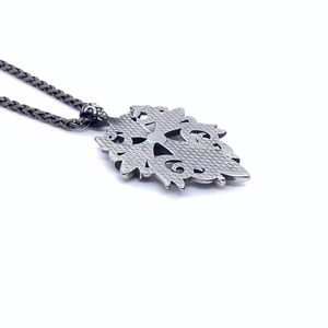 Detail of vintage titanium steel cross pendant with brushed finish and woven chain