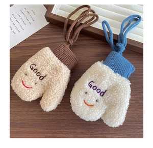 Nahaufnahme der Strick-Plüschhandschuhe mit Lächeln-Stickerei und Lammwolltextur