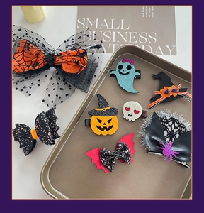 Detailed view of Halloween hair clips set with pumpkin, ghost, and bat wing designs
