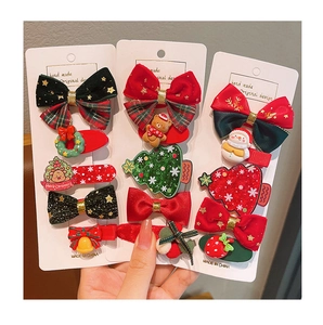 Close-up of festive Christmas hair clips featuring snowmen, bows, and sequins on display cards