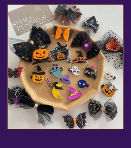 Flat lay of Halloween hair clips featuring pumpkins, ghosts, and sequin bows on a tray