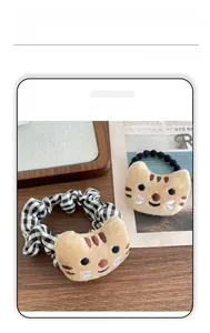 Détail de chouchous chat en peluche avec tissu à carreaux et cordon élastique noir