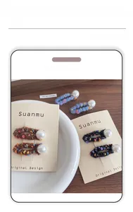 Close-up of handmade felt BB hair clips with vintage knit texture and faux pearl detail