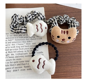 Vue détaillée d'accessoires de cheveux en peluche chat et poisson sur chouchous et serre-tête