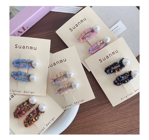 Detailed view of handmade wool felt BB hair clips with decorative pearls in various colors