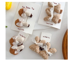 Détail de pinces à cheveux en tissu avec champignons et nœuds sur carte cadeau