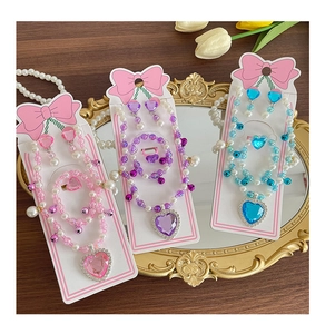 Close-up of girls beaded jewelry sets with heart gems on vintage mirror background