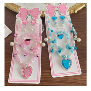 Detailed set of beaded children jewelry with heart gems on a decorative card