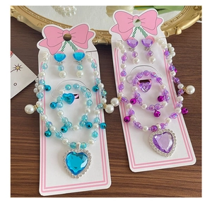 Detailed set of beaded children jewelry with heart-shaped gems and pearls on display